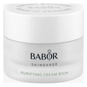 Eine Glastopfdose mit einem weißen Deckel, beschriftet mit "BABOR SKINOVAGE PURIFYING CREAM RICH".