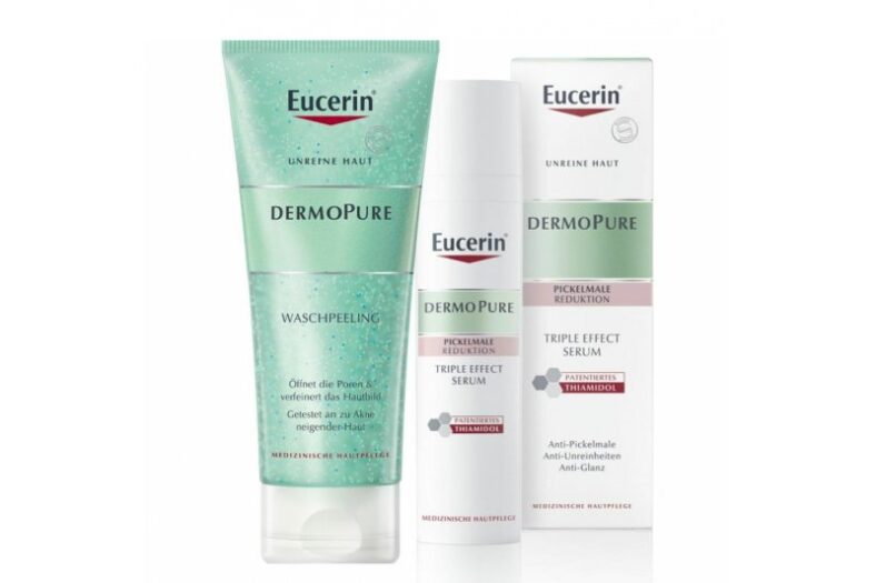 Drei Eucerin Dermopure Produkte: Waschpeeling in Tube und zwei Flakons für das Triple Effect Serum zur Reduktion von Pickelmalen.