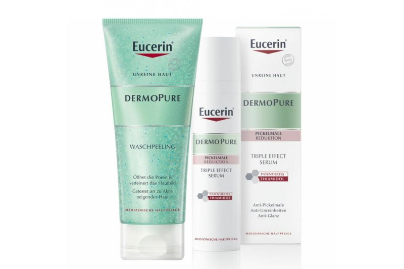 Drei Eucerin Dermopure Produkte: Waschpeeling in Tube und zwei Flakons für das Triple Effect Serum zur Reduktion von Pickelmalen.