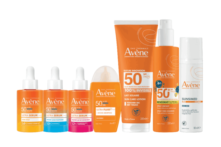Sonnenpflegeprodukte der Marke Avène in orangefarbener Verpackung, darunter Seren, Lotionen und Sprays mit hohem Lichtschutzfaktor.