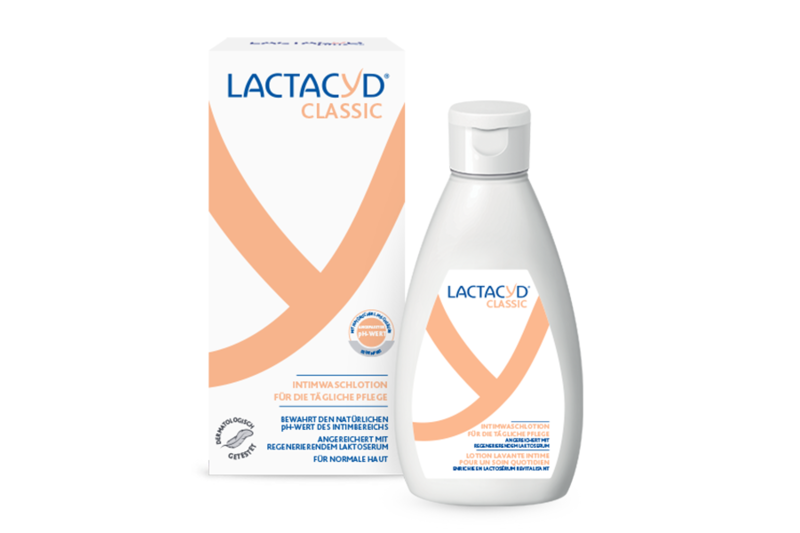 Lactacyd.png Lactacyd Classic Intimwaschlotion in einem weißen Flacon neben der Verpackung mit orangefarbenen Akzenten und Beschreibung oben.